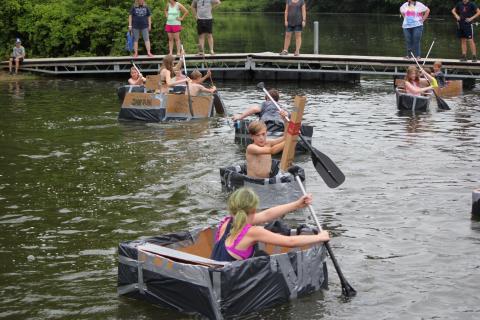 kids in a boat paddling on a lake