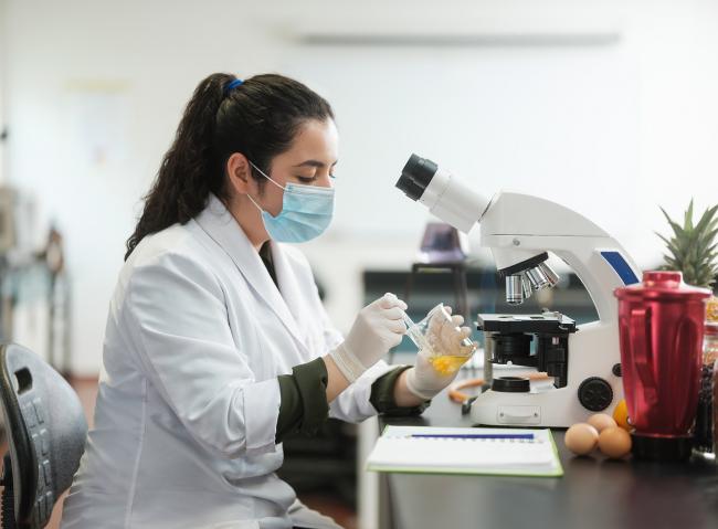 Food scientist in front of microscope