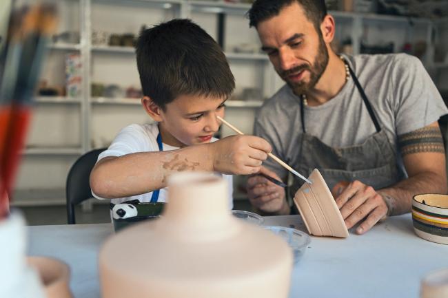 student and ceramic teacher glaze a ceramic bowl