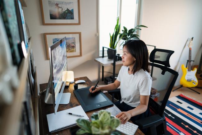 woman at computer drawing on tablet